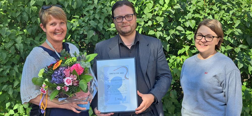 personer med blombukett och diplom