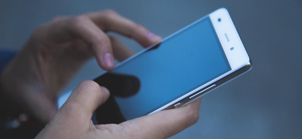 två händer som håller i en telefon