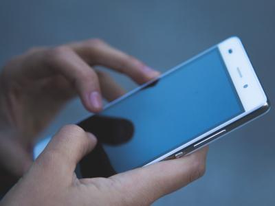 två händer som håller i en telefon