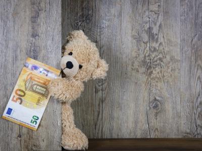 leksaksbjörn som håller i en 50 euros sedel